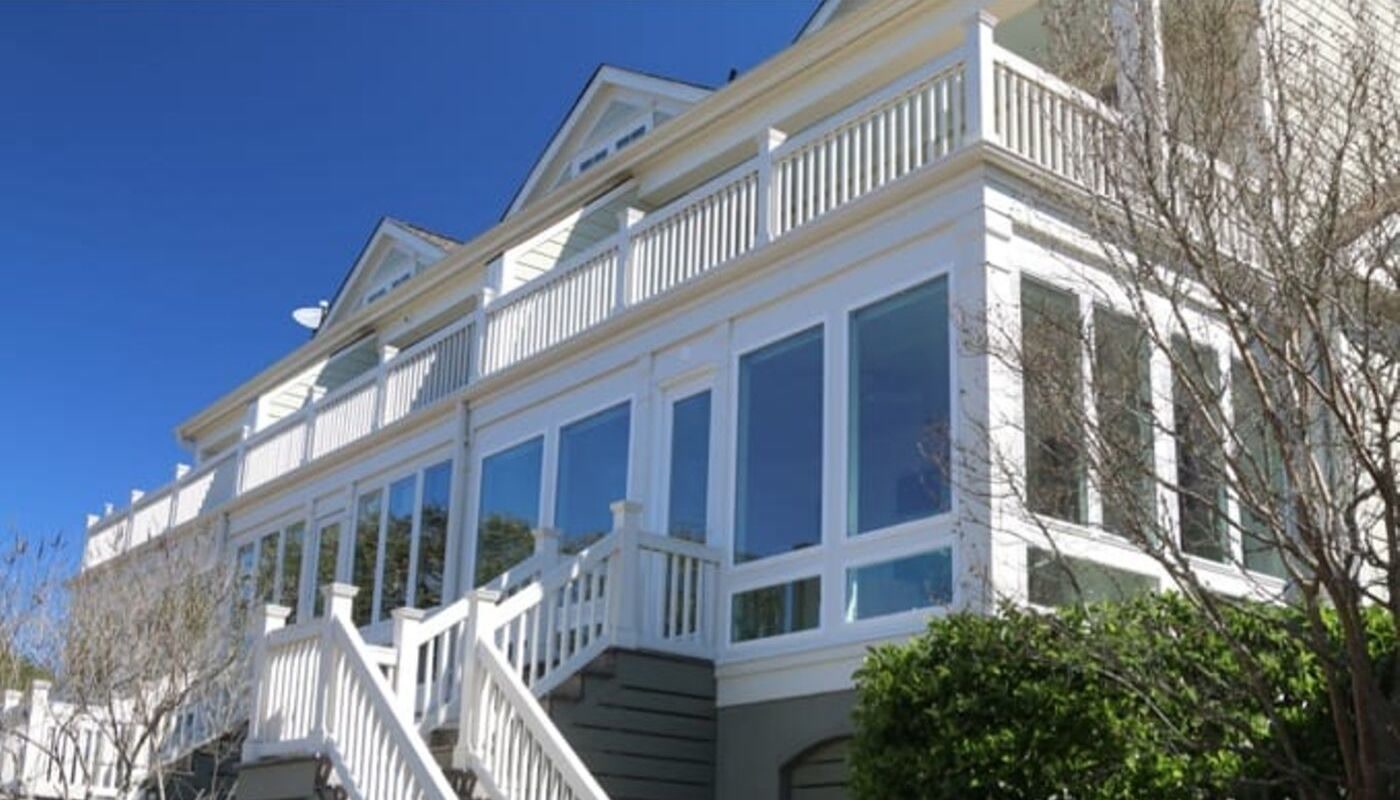Glassed-in porch conversion by Muhler on an elevated Lowcountry home