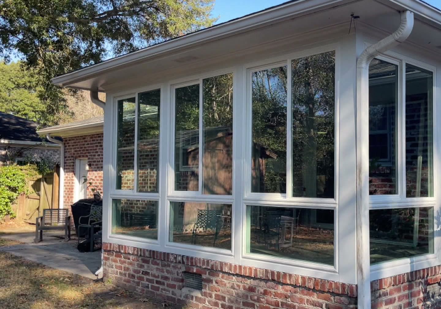 Exterior of a Muhler Any-Season Room on a Lowcountry brick ranch, glass set in a white welded vinyl frame above a brick knee wall